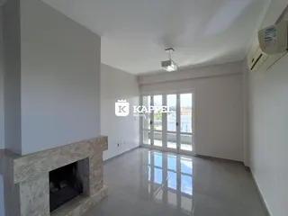 Sala de estar com lareira e porta de vidro que dá para a área externa.