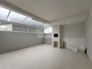 Imagem de um ambiente interno amplo com piso de cerâmica e teto inclinado.