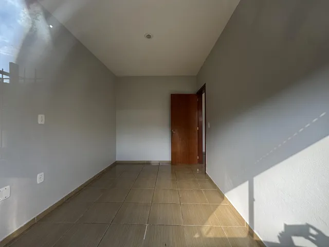 Corredor com piso de cerâmica e porta de madeira.