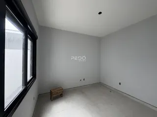 Ambiente interno de uma sala com paredes brancas e piso claro.