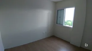 Interior de um cômodo com piso de madeira e paredes brancas.