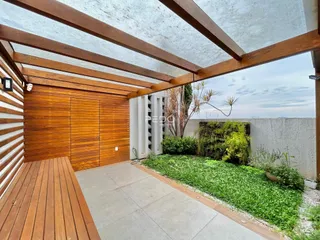 Vista externa de uma área com piso de madeira e jardim em Lajeado, Brasil.
