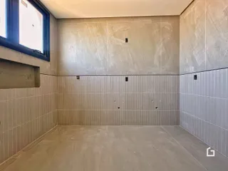 Parede revestida com azulejos claros em um ambiente interno.
