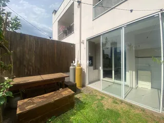 Vista da fachada de uma residência em Lajeado, Brasil, com muro de madeira e jardim.