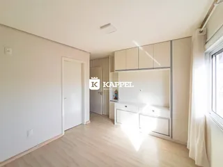 Foto de uma sala com armários brancos e piso de madeira clara.