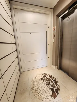 Foto de um corredor interno com piso de cerâmica e uma porta branca.