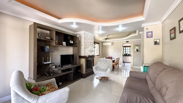 Sala de estar com decoração moderna e lareira em Lajeado.