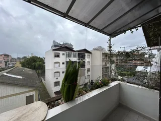 Vista de uma varanda com vegetação e edifícios ao fundo em Lajeado.