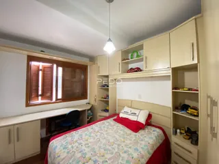 Quarto com armários embutidos e janela de madeira.