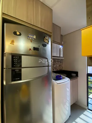 Foto de uma cozinha com geladeira e máquina de lavar roupa em aço inoxidável.