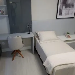 Foto de um quarto com cama de casal e piso claro.