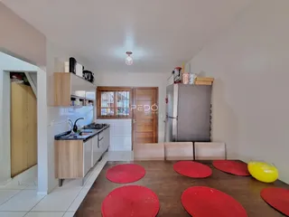 Cozinha e sala de jantar com mesa de madeira no interior da residência.