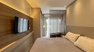 Quarto com cama e televisão em ambiente moderno.