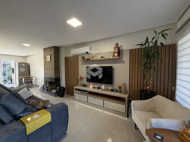 Sala de estar moderna com sofá azul e lareira em um imóvel no Brasil.