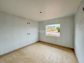 Um cômodo vazio com paredes brancas e piso de cerâmica.