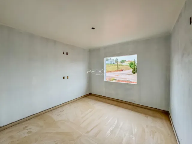 Um cômodo vazio com paredes brancas e piso de cerâmica.