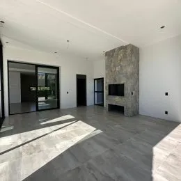 Sala ampla com piso de concreto polido e portas de vidro.