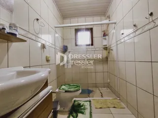 Foto de um banheiro com azulejos brancos.