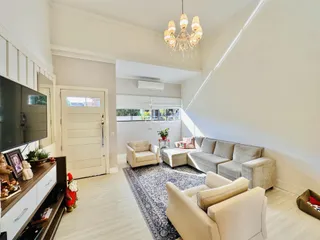 A sala de estar apresenta um sofá grande e poltronas em um ambiente claro.