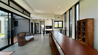 Sala de estar com grandes portas de vidro e móveis de madeira em um apartamento.