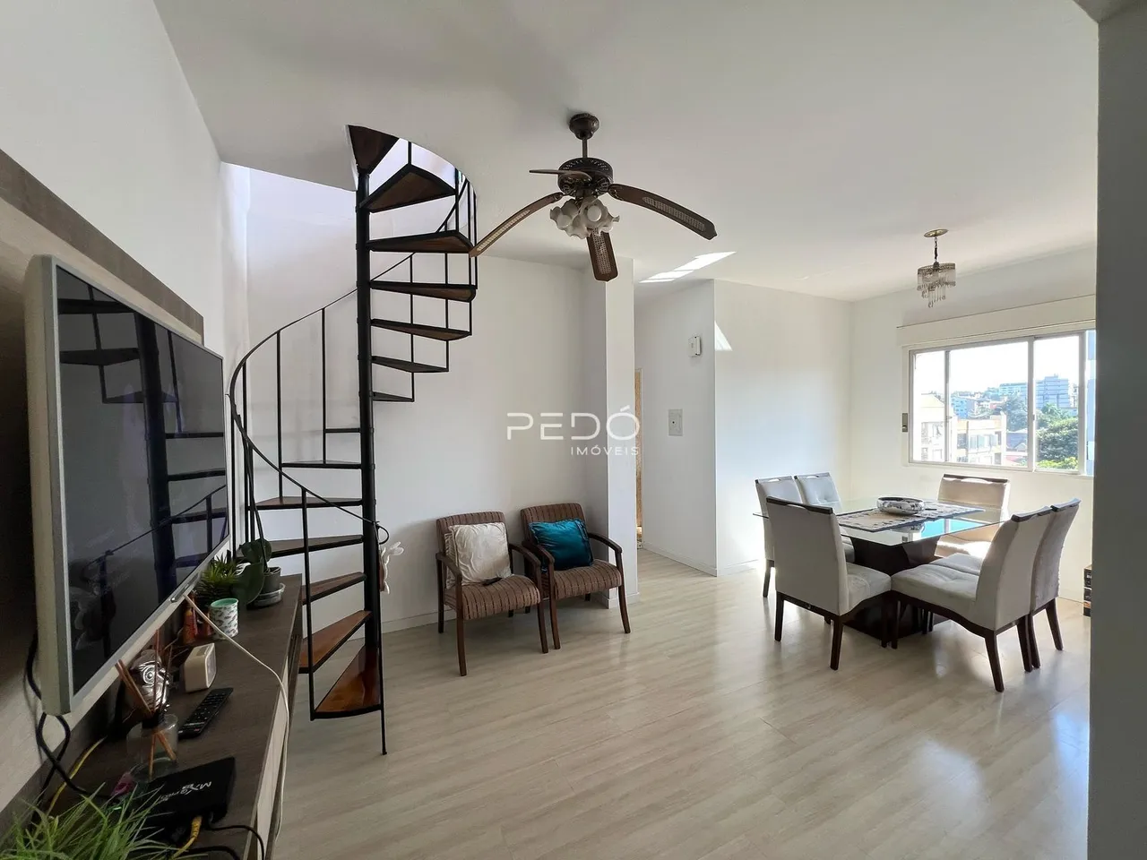 Sala de estar com escadaria e área de jantar em um imóvel.