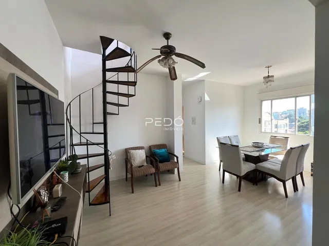 Sala de estar com escadaria e área de jantar em um imóvel.