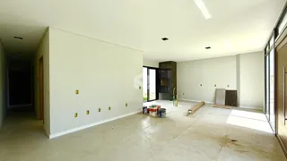 Uma sala ampla e vazia com piso claro e paredes brancas.
