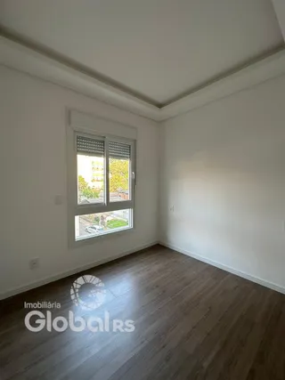 Ambiente interno com piso de madeira e janela iluminada.