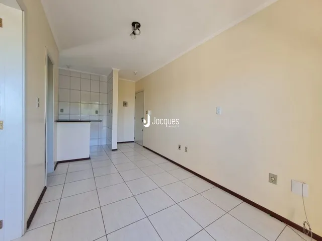 Corredor interno de uma residência com piso de cerâmica clara.