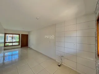 Hall de entrada com piso cerâmico e porta de madeira.