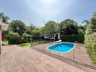 Foto de uma área externa com piscina e deck de madeira.