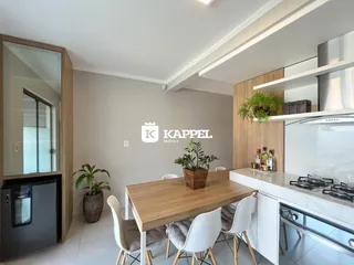 Foto de uma sala de jantar com mesa de madeira e bancada de cozinha.