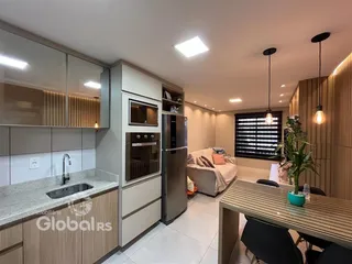 Interior de uma cozinha e sala de estar moderna com armários e eletrodomésticos em aço inoxidável.