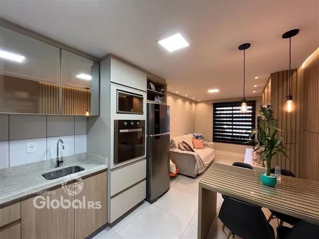 Interior de uma cozinha e sala de estar moderna com armários e eletrodomésticos em aço inoxidável.
