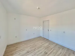 Ambiente interno de uma sala com piso de madeira clara.