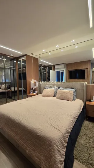 Quarto moderno com cama grande e piso de madeira em apartamento em Lajeado.