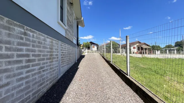 Parede de tijolos e caminho de cascalho de uma propriedade em Lajeado.