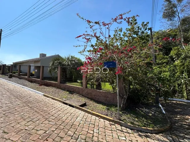Vista da fachada de uma propriedade em Lajeado, Brasil, com muro e vegetação.