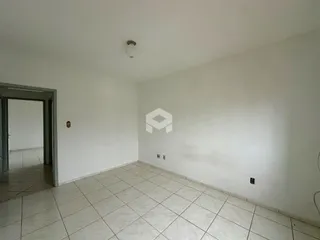 Uma sala interna com piso de cerâmica clara e porta de acesso.