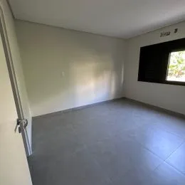Ambiente interno com paredes brancas e piso cinza.