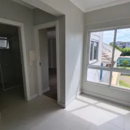 Hall de entrada com paredes brancas e piso claro.