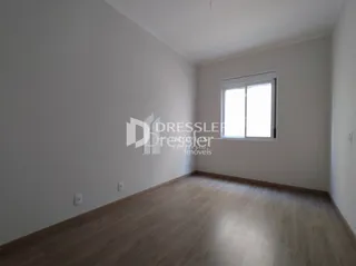 Ambiente interno com piso de madeira clara e paredes brancas.