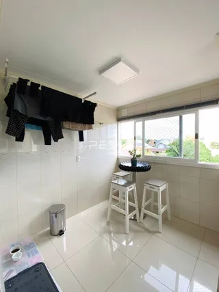 Ambiente interno com piso de cerâmica e janela de grande porte.