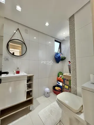 Foto de um banheiro moderno com revestimento cerâmico e louças brancas.