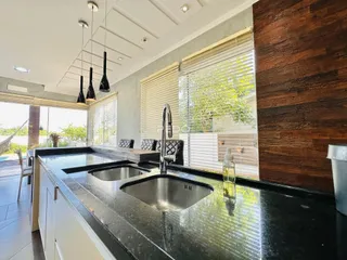 Cozinha moderna com bancadas escuras e iluminação natural.