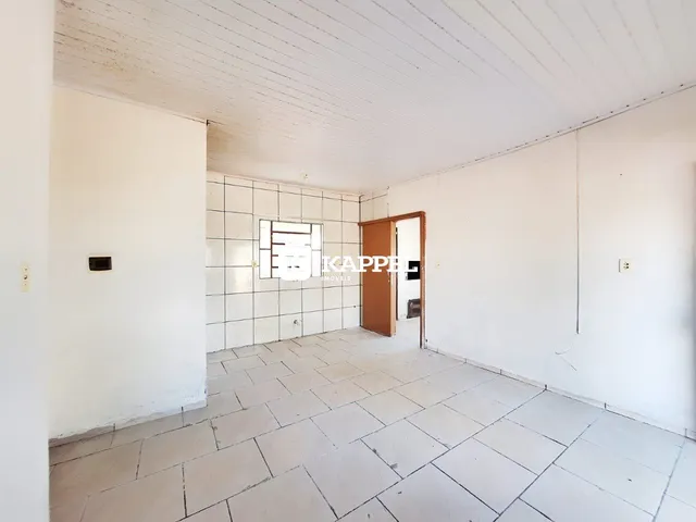 Ambiente interno com piso de cerâmica claro e paredes brancas.
