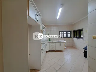 Foto de uma cozinha com armários brancos e piso de cerâmica.