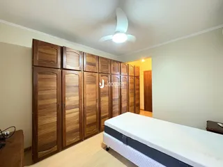 Quarto com armários de madeira e cama no interior da residência.