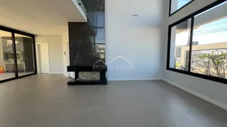 Sala de estar ampla com lareira e portas de vidro.