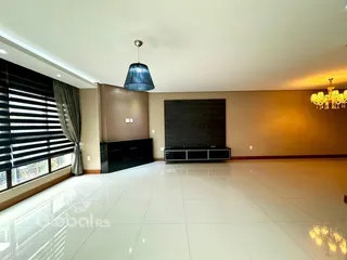 A sala de estar possui piso de cerâmica claro e paredes em tons terrosos.